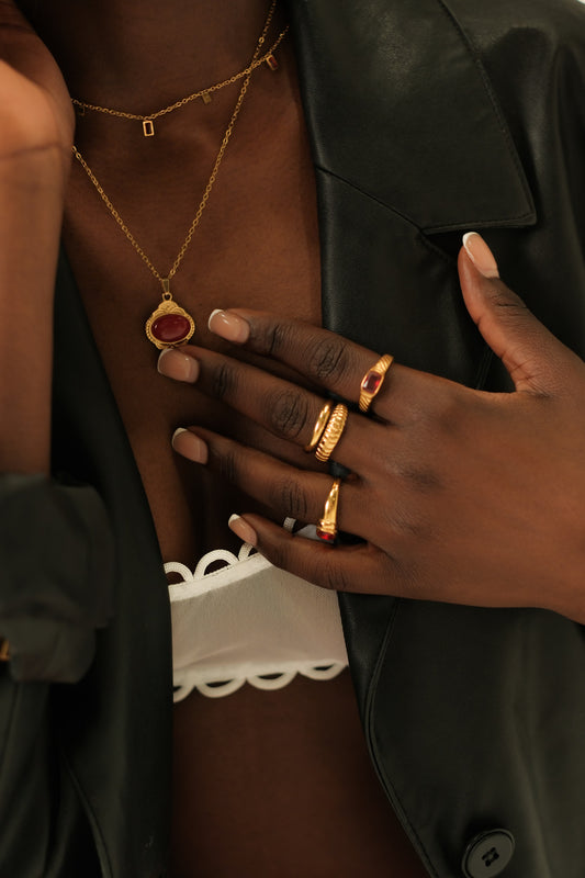 Close-up of a person wearing gold jewelry with a dark background