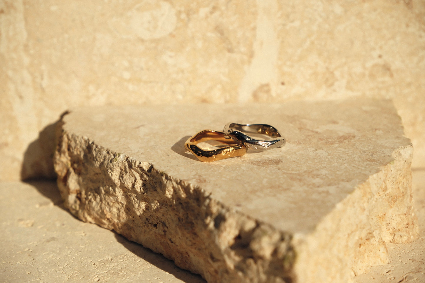 Gold and silver rings on a stone surface