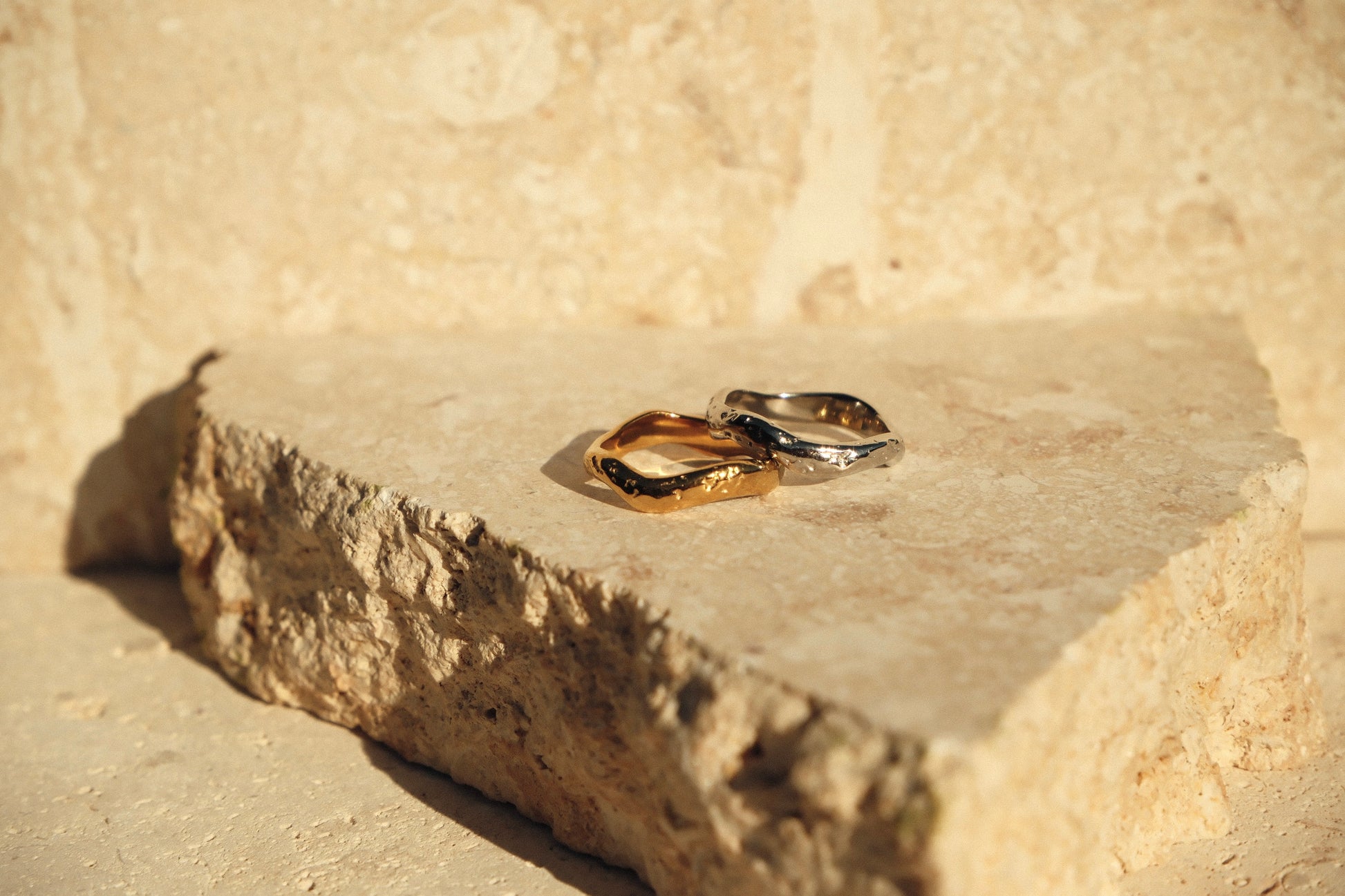 Gold and silver rings on a stone surface