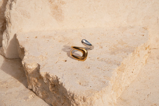 Gold and silver ring on a textured stone surface
