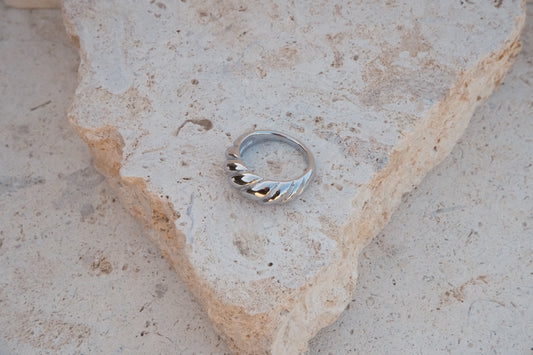 Silver ring on a textured stone surface