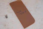 Brown phone case with 'Sol & Aura' branding on a textured surface