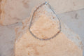 Silver chain bracelet on a textured stone surface