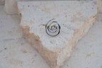 Metallic spiral ring on a stone surface