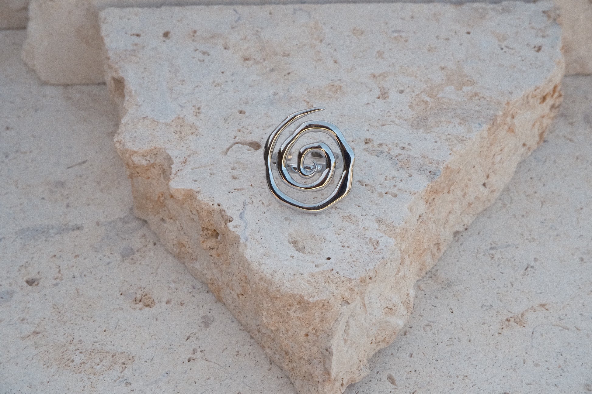 Metallic spiral ring on a stone surface