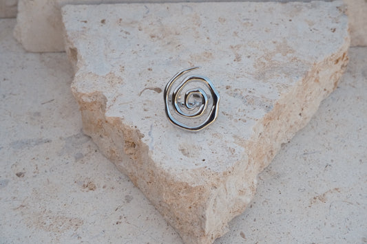 Metallic spiral ring on a stone surface
