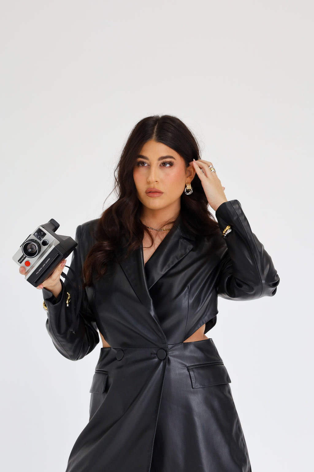 Sol & Aura - Alaska earrings on woman in black leather dress holding vintage polaroid camera