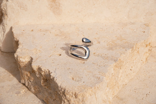 Silver ring on a textured stone surface