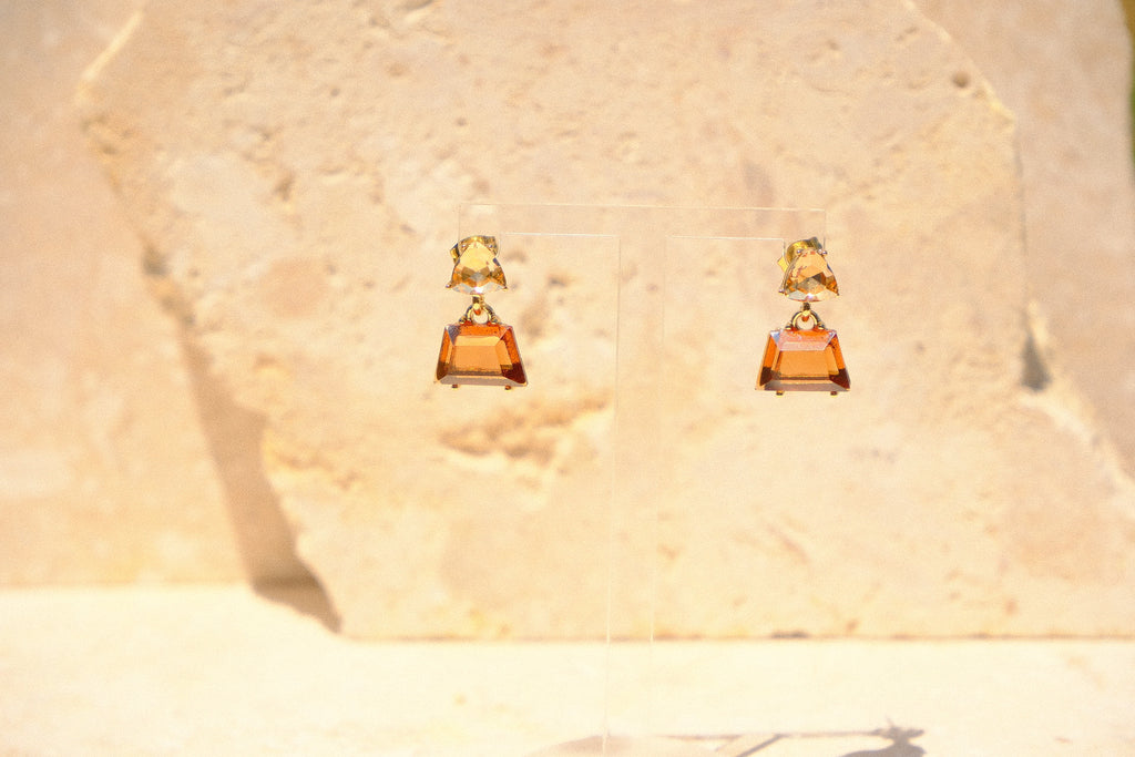 Sol & Aura - Brown and beige glass crystal-like gemstone drop earrings against stone background
