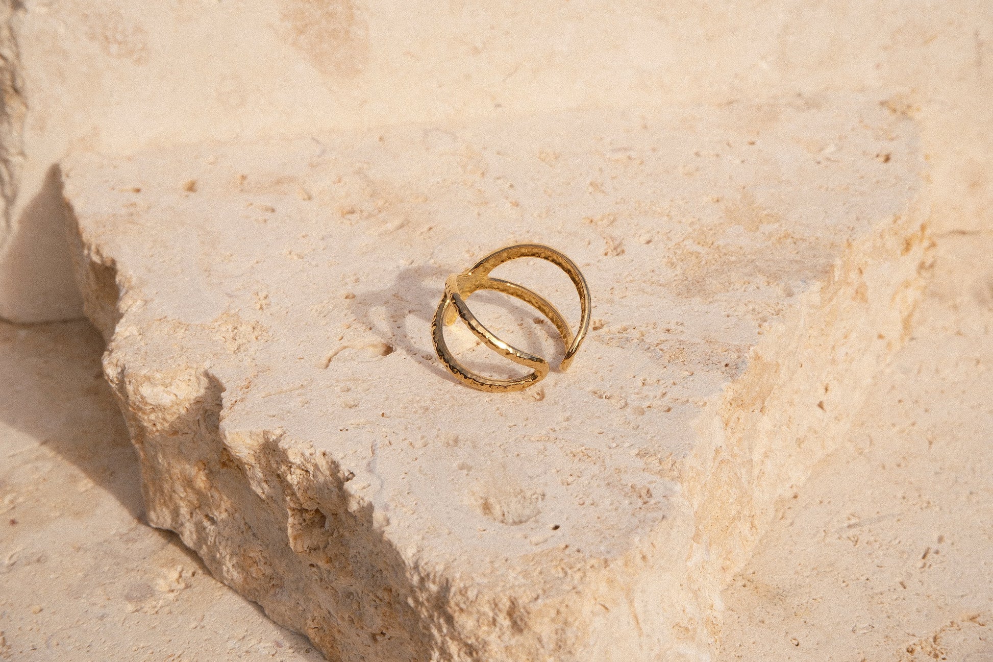 Gold starfish ring on a textured stone surface