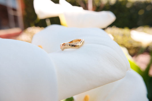 Gold ring on a white flower with a blurred background
