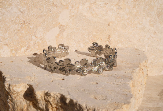 Silver floral bracelet on a stone surface