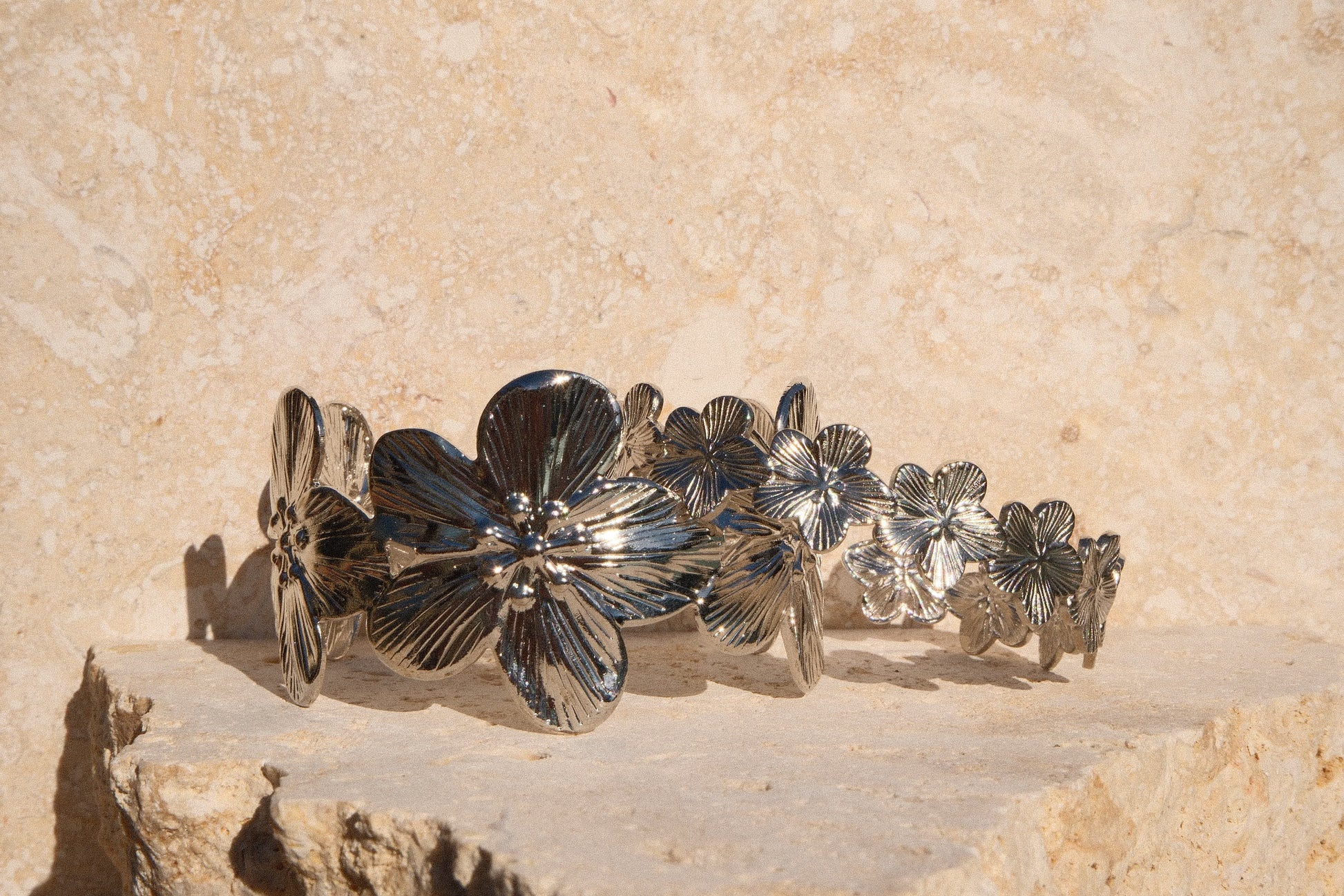 Silver floral bracelet on a stone surface