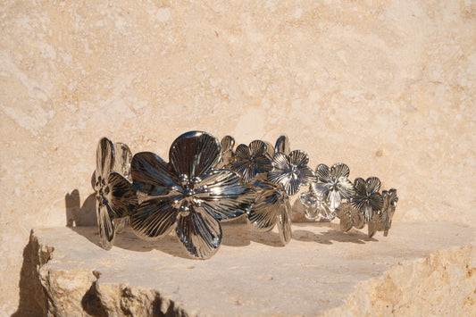 Silver floral bracelet on a stone surface
