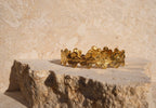 Gold bracelet with floral design on a stone surface