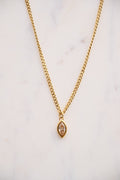 Gold necklace with a pendant on a light background