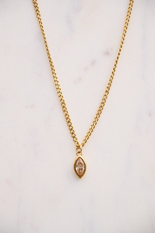 Gold necklace with a pendant on a light background