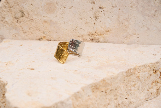 Gold and silver ring on a textured stone surface