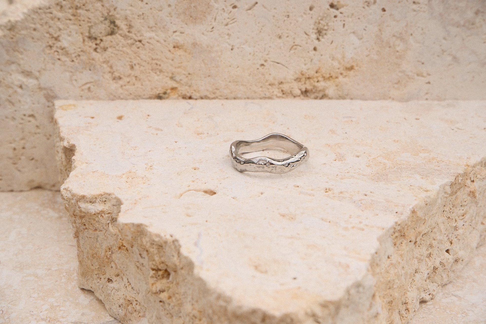 Silver ring on a textured stone surface