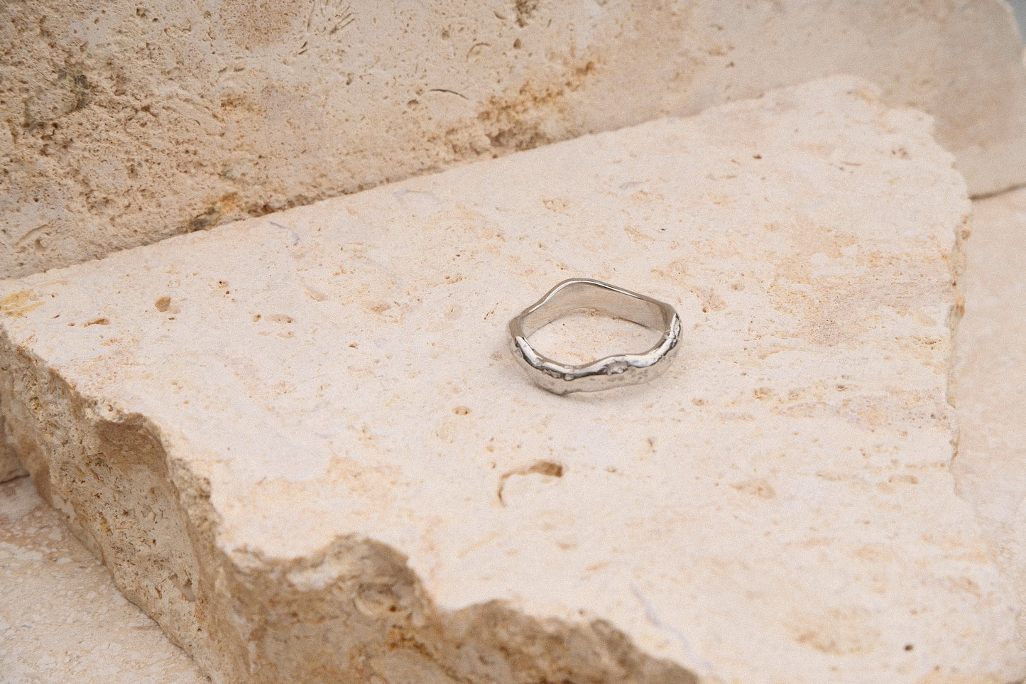 Silver ring on a textured stone surface