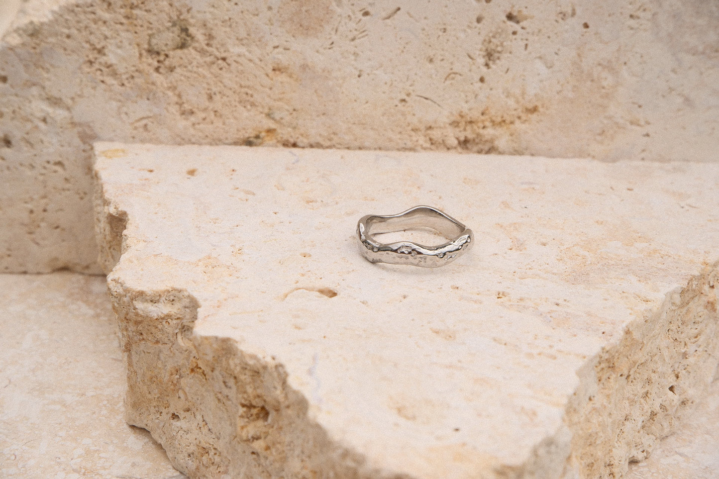 Silver ring on a textured stone surface