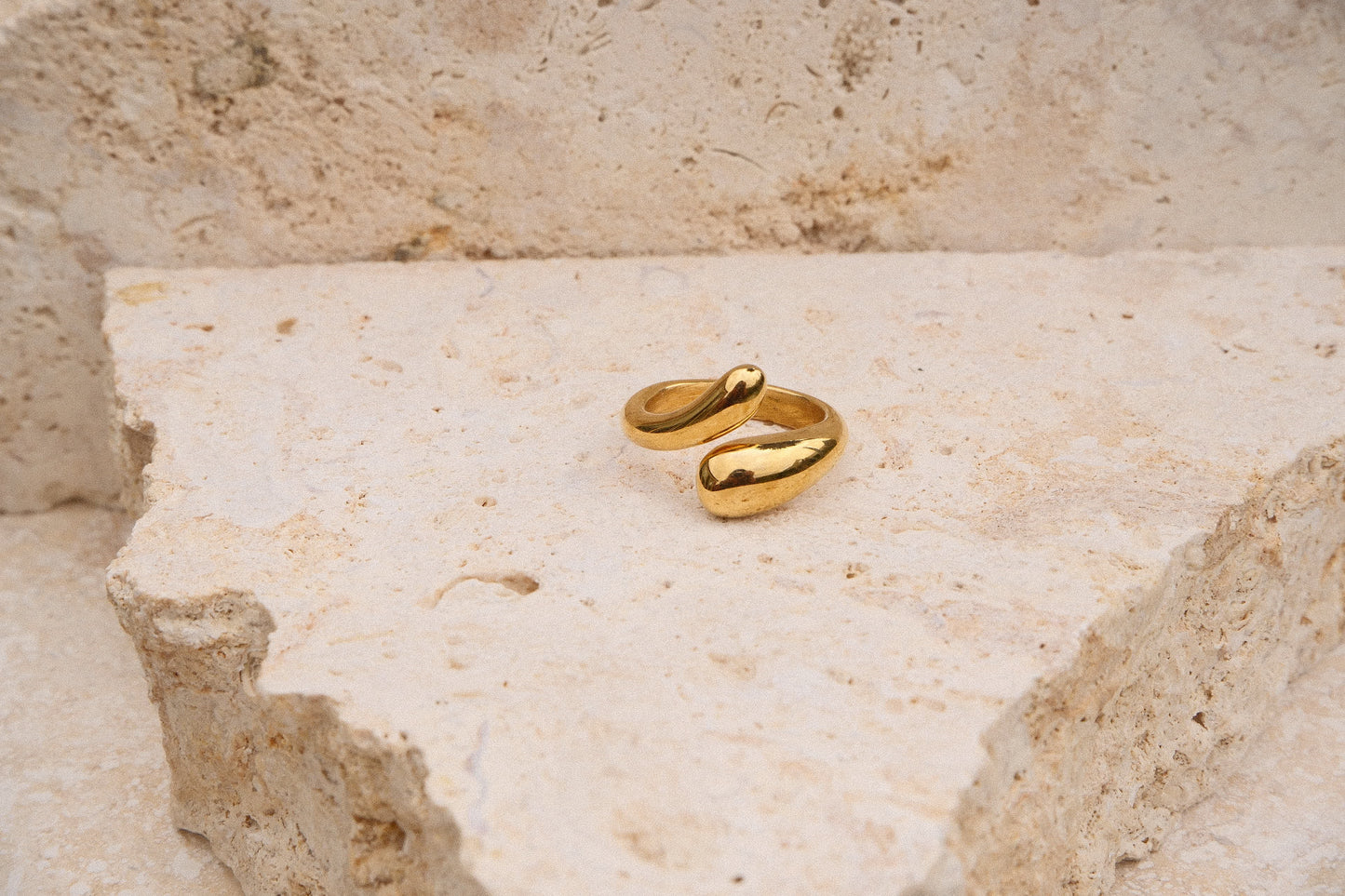 Gold ring on a textured beige surface