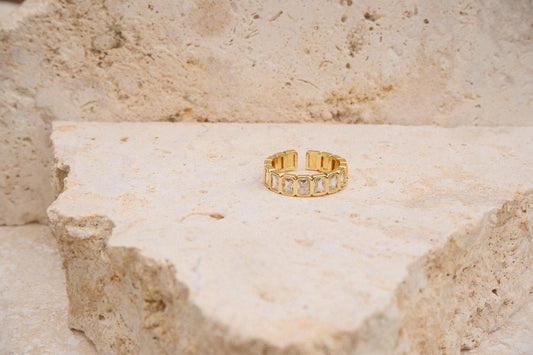 Gold ring on a textured beige surface