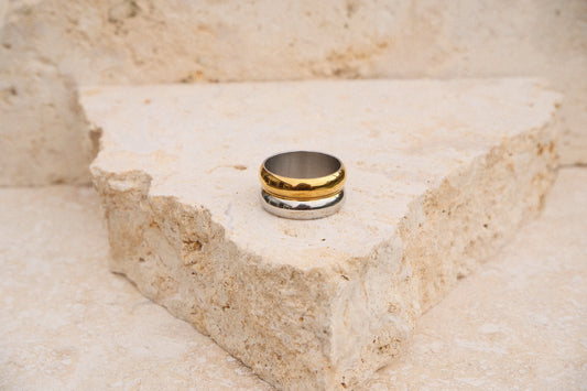 Gold and silver ring on a textured stone surface