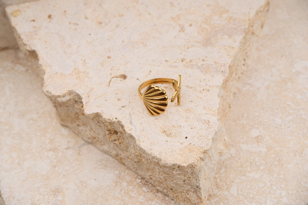 Gold ring on a textured beige surface
