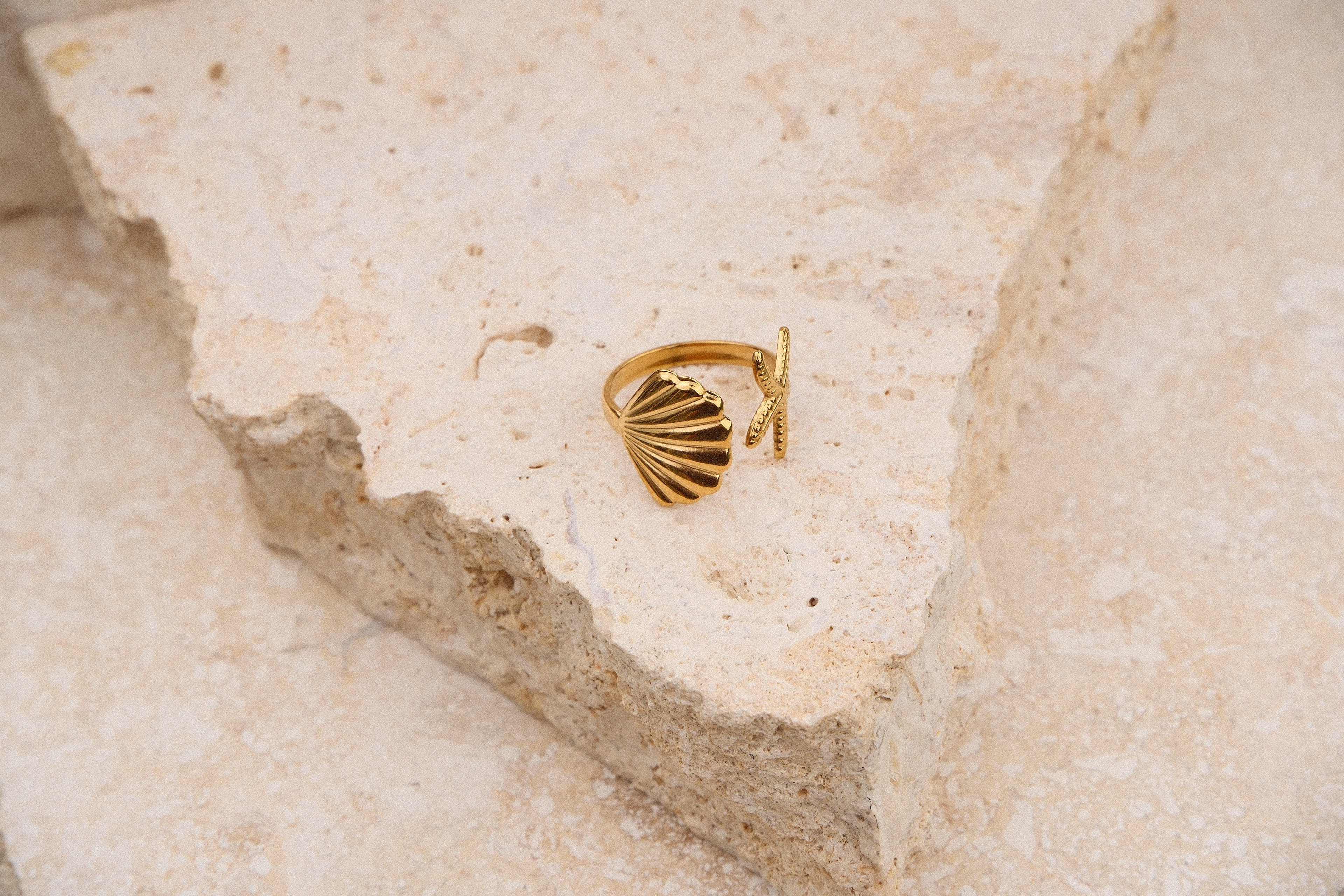 Gold ring on a textured beige surface