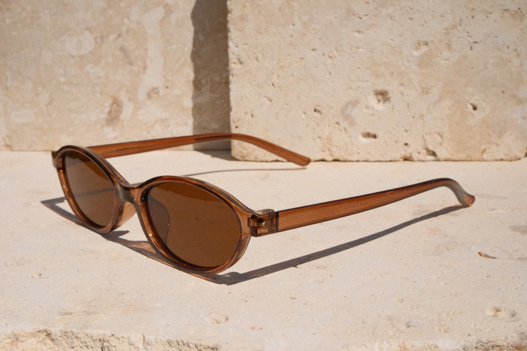 Brown sunglasses on a light stone surface
