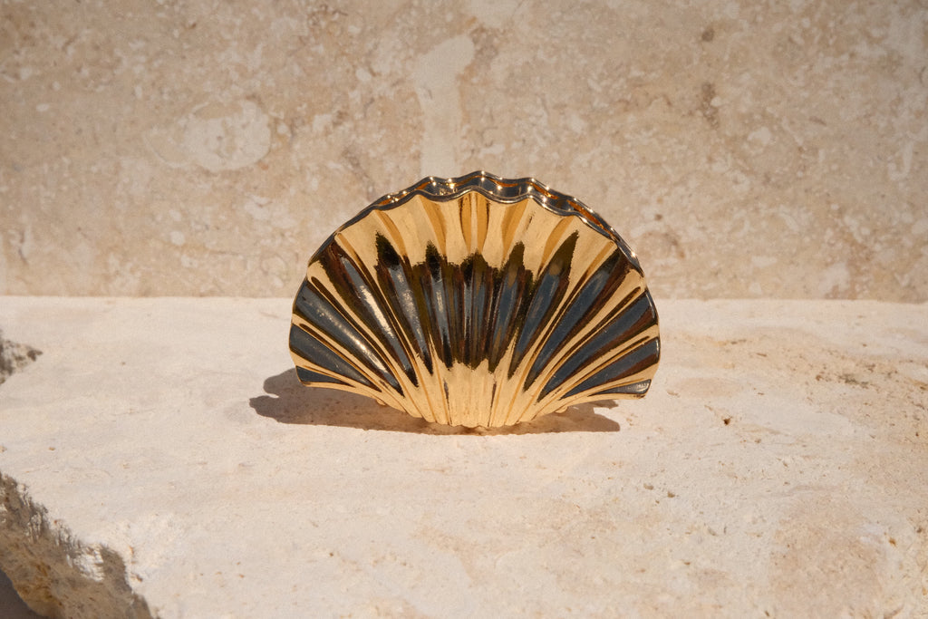Shell-shaped claw clip on a stone surface