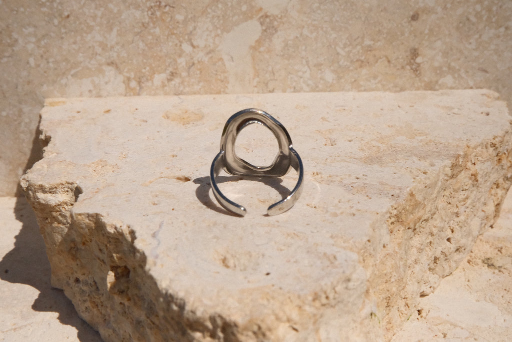 Silver ring on a textured stone surface