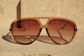 Brown sunglasses with a beige background