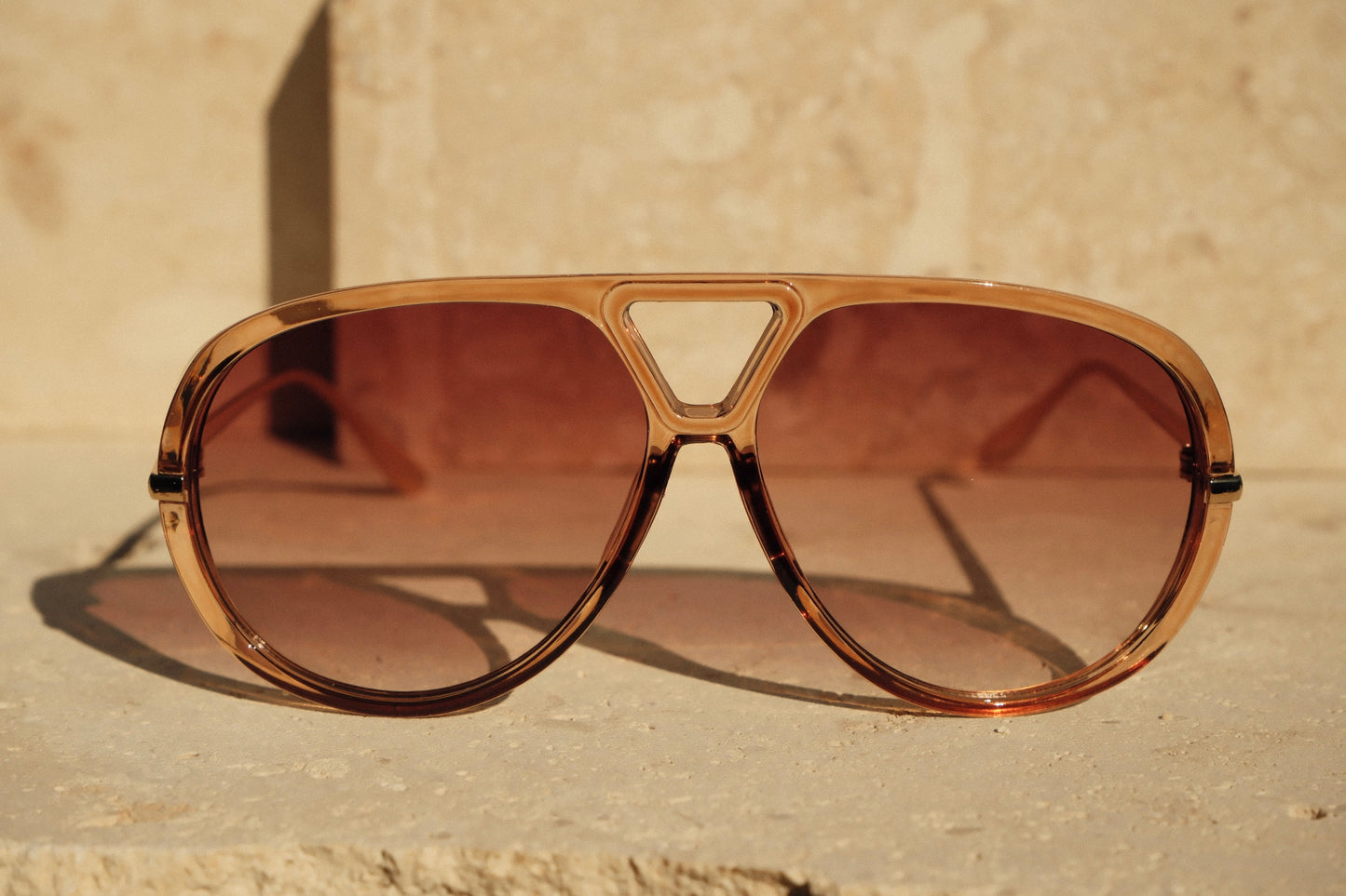 Brown sunglasses with a beige background