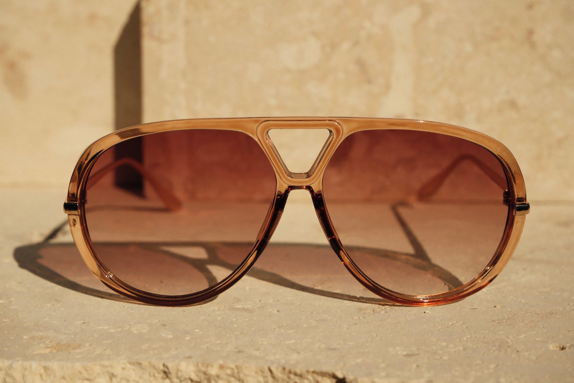 Brown sunglasses with a beige background