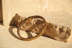 Gold bracelet on a textured stone surface
