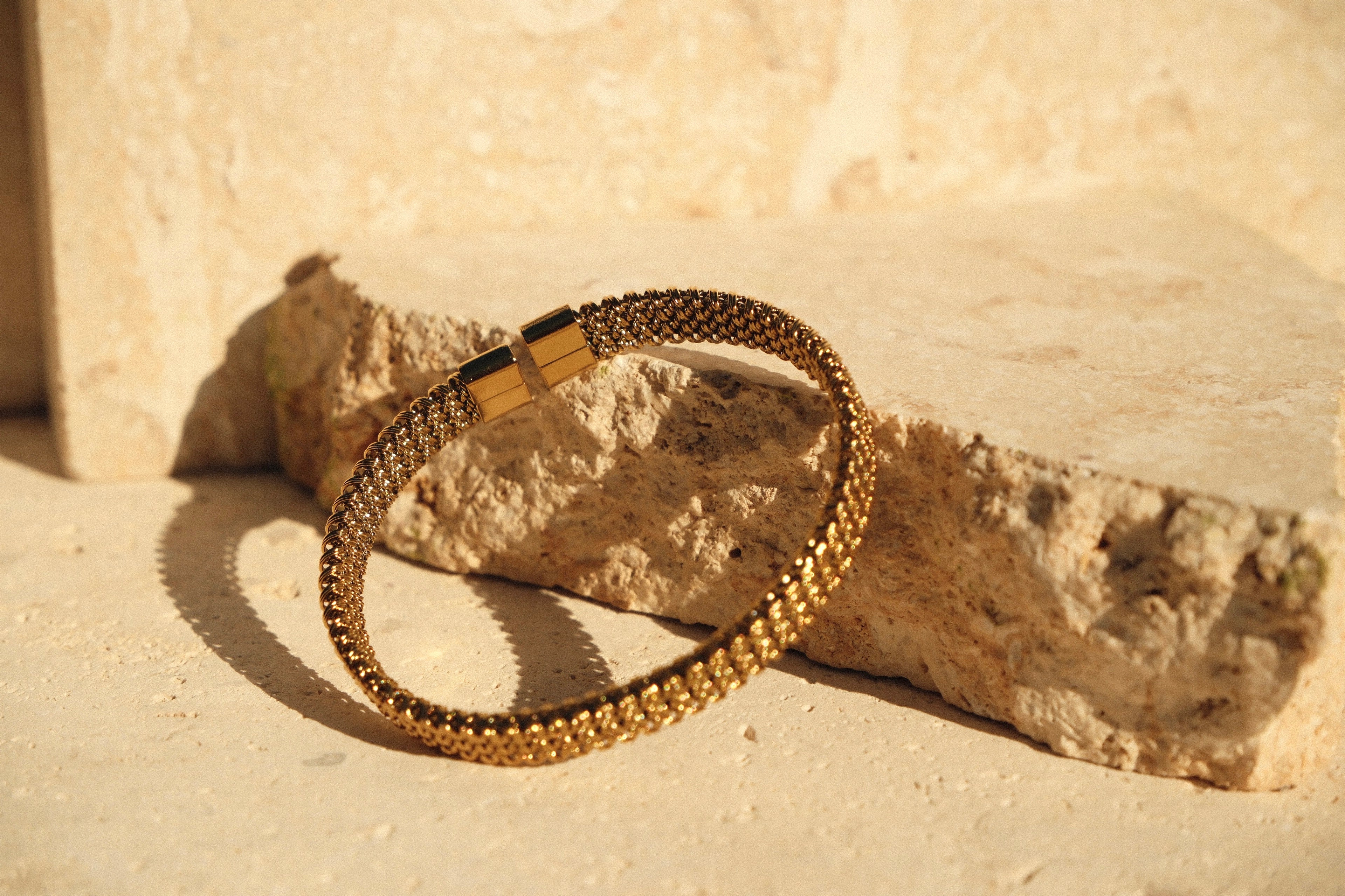 Gold bracelet on a textured stone surface