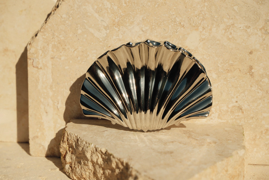 Shell-shaped claw clip on a stone surface