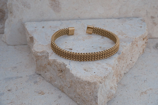 Gold bracelet on a textured stone surface