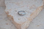 Silver ring on a textured stone surface