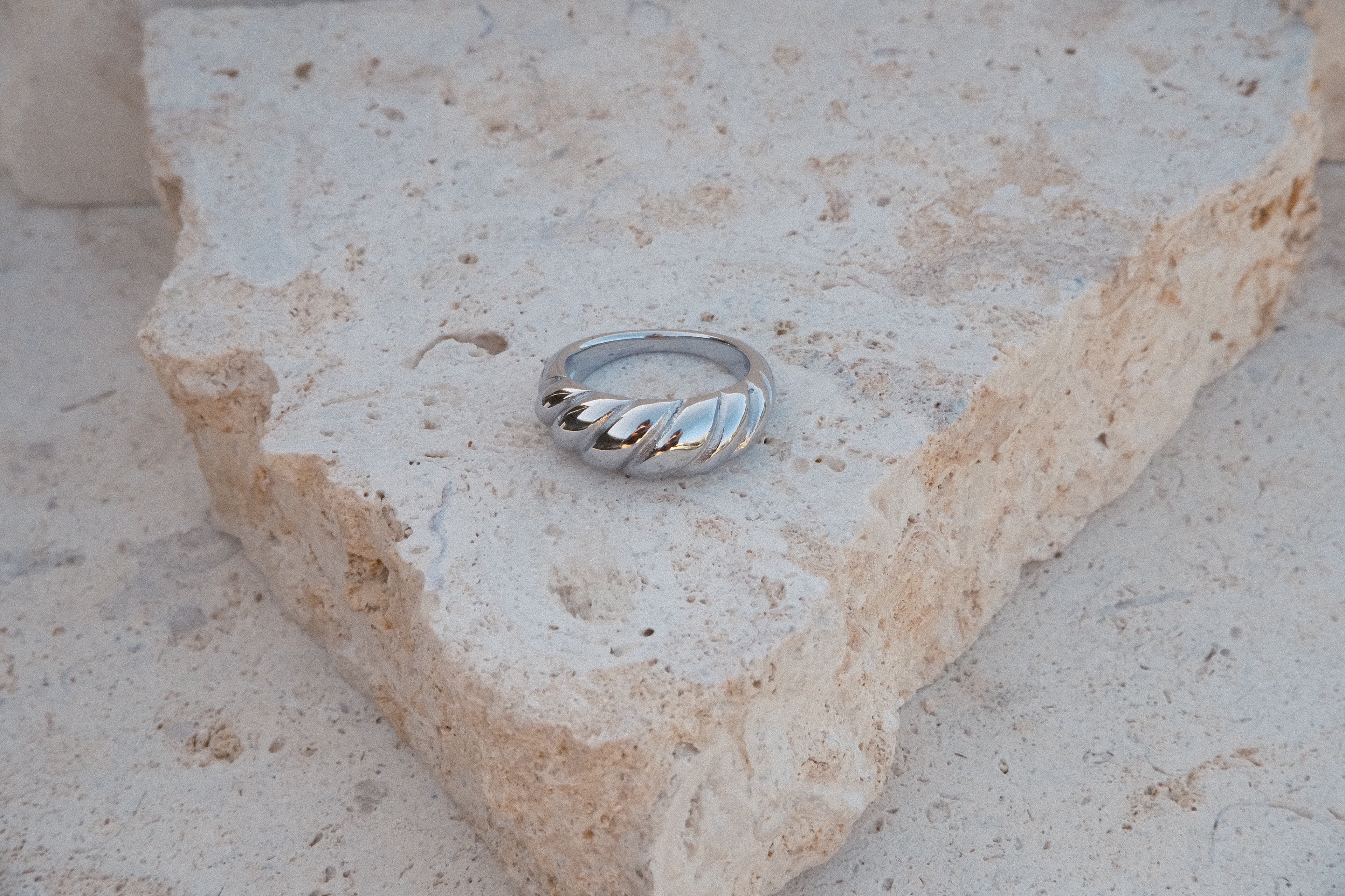 Silver ring on a textured stone surface