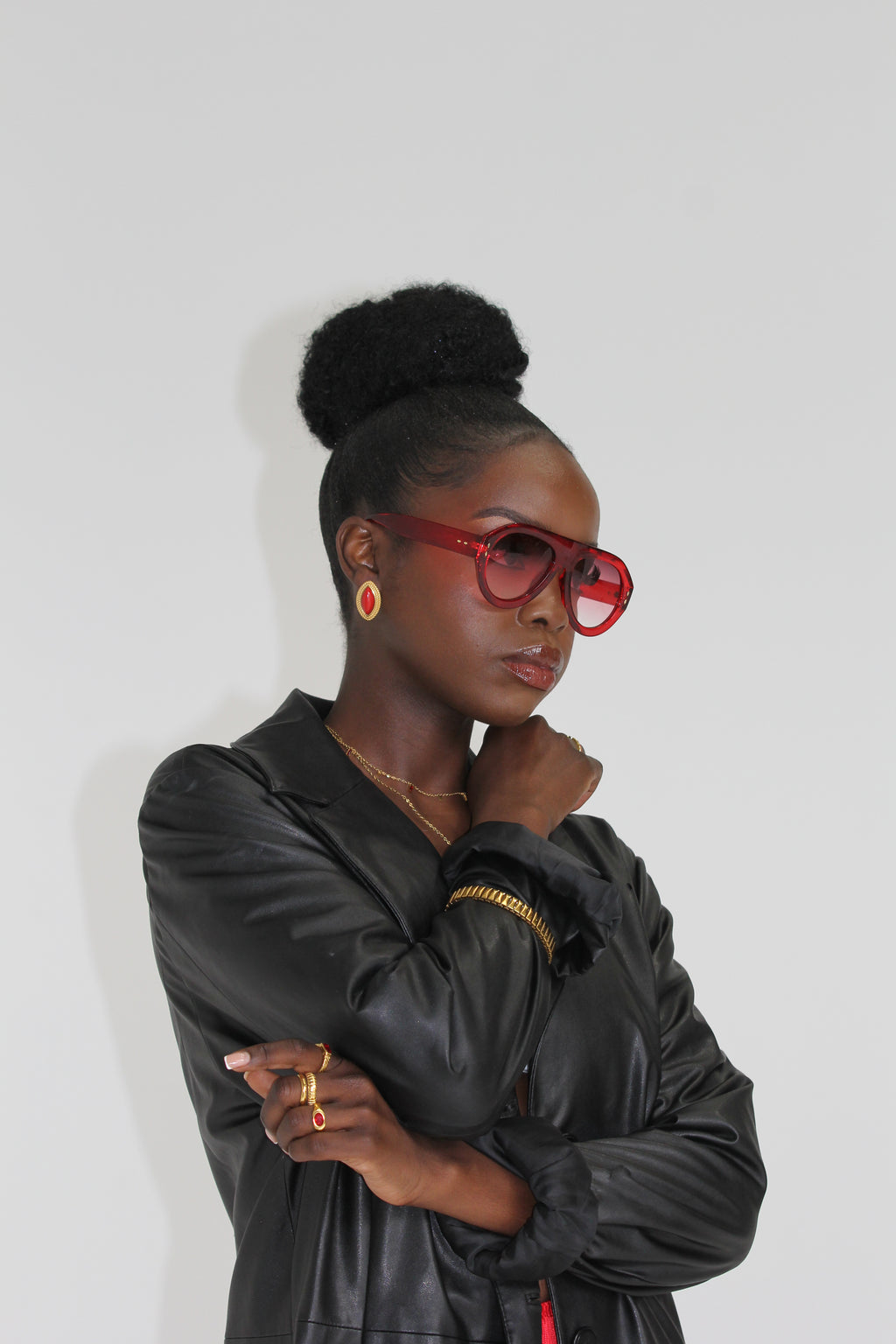 Sol & Aura - FIESTA Sunglasses and red PHARAOH Earrings on woman with black leather jacket 