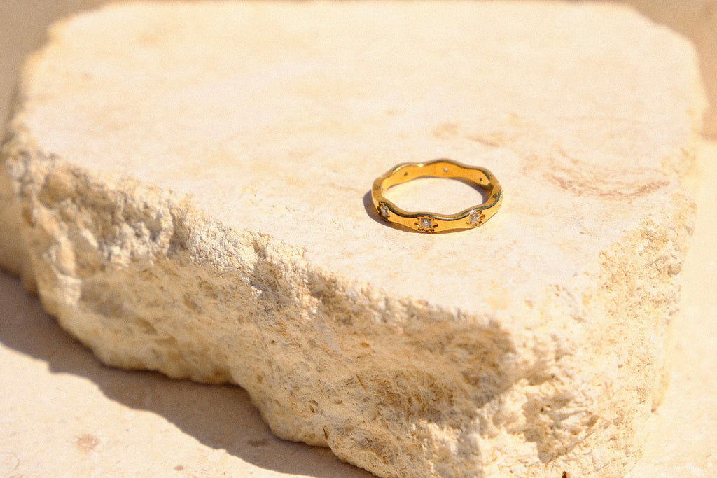 Sol & Aura - Gold detailed ring on a textured stone surface