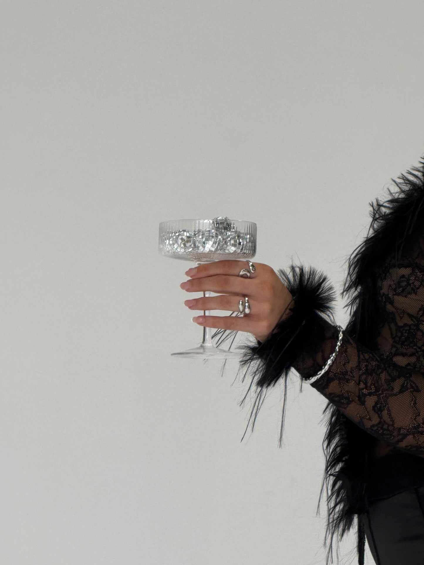 Hand holding a decorative glass with a plain background