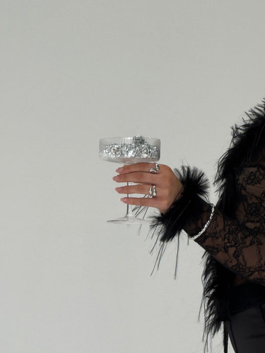 Hand holding a decorative glass with a plain background