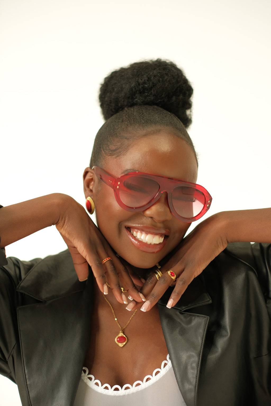Woman wearing red sunglasses and a black leather jacket against a white background