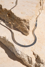 Sol & Aura - Medusa Necklace coiled on a rocky surface