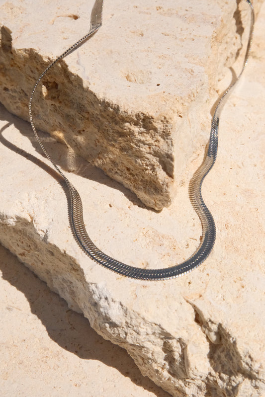 Sol & Aura - Medusa Necklace coiled on a rocky surface