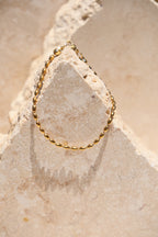 Sol & Aura - Minnie Bracelet - Gold beaded chain bracelet on a textured stone surface
